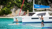 Stand Up Paddling Next To Catamaran At Corfu Island Greece
